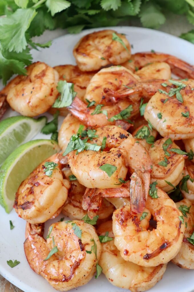 grilled shrimp piled on plate with fresh cilantro