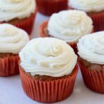 pumpkin cupcakes with frosting sitting on white plate