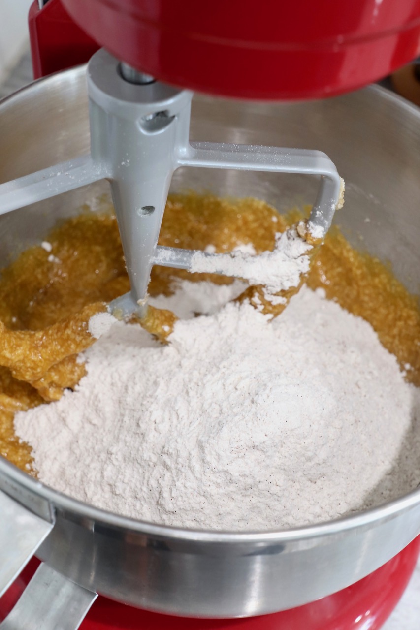 flour mixture in stand mixer with pumpkin cupcake batter