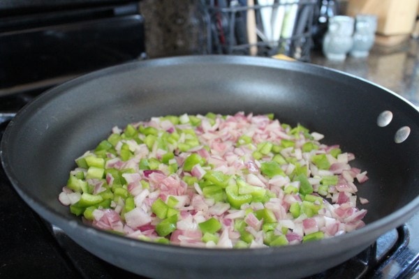 onions and peppers cooking in a skillet.