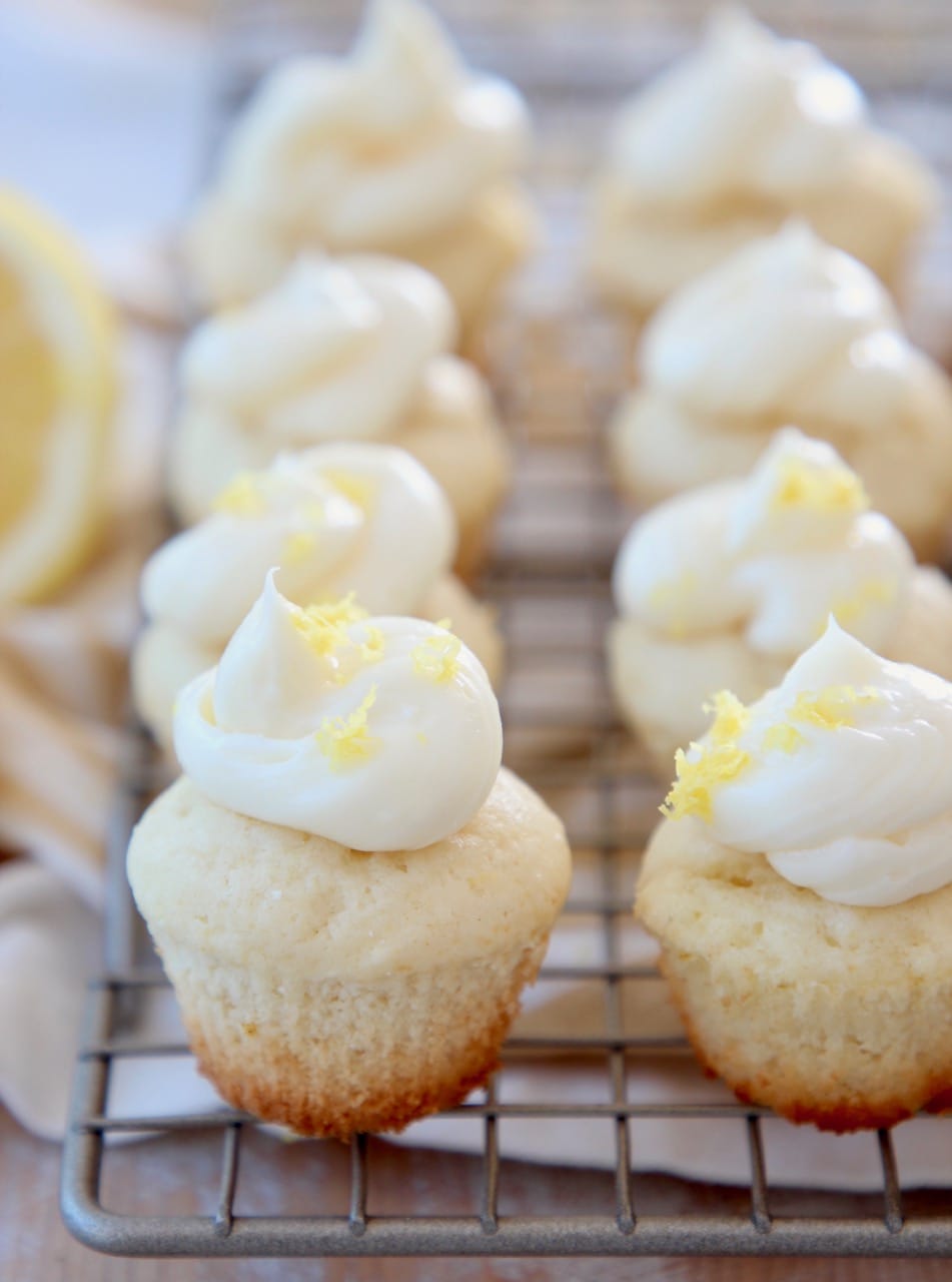 Miniature lemon cupcakes with lemon buttercream frosting on wire baking rack
