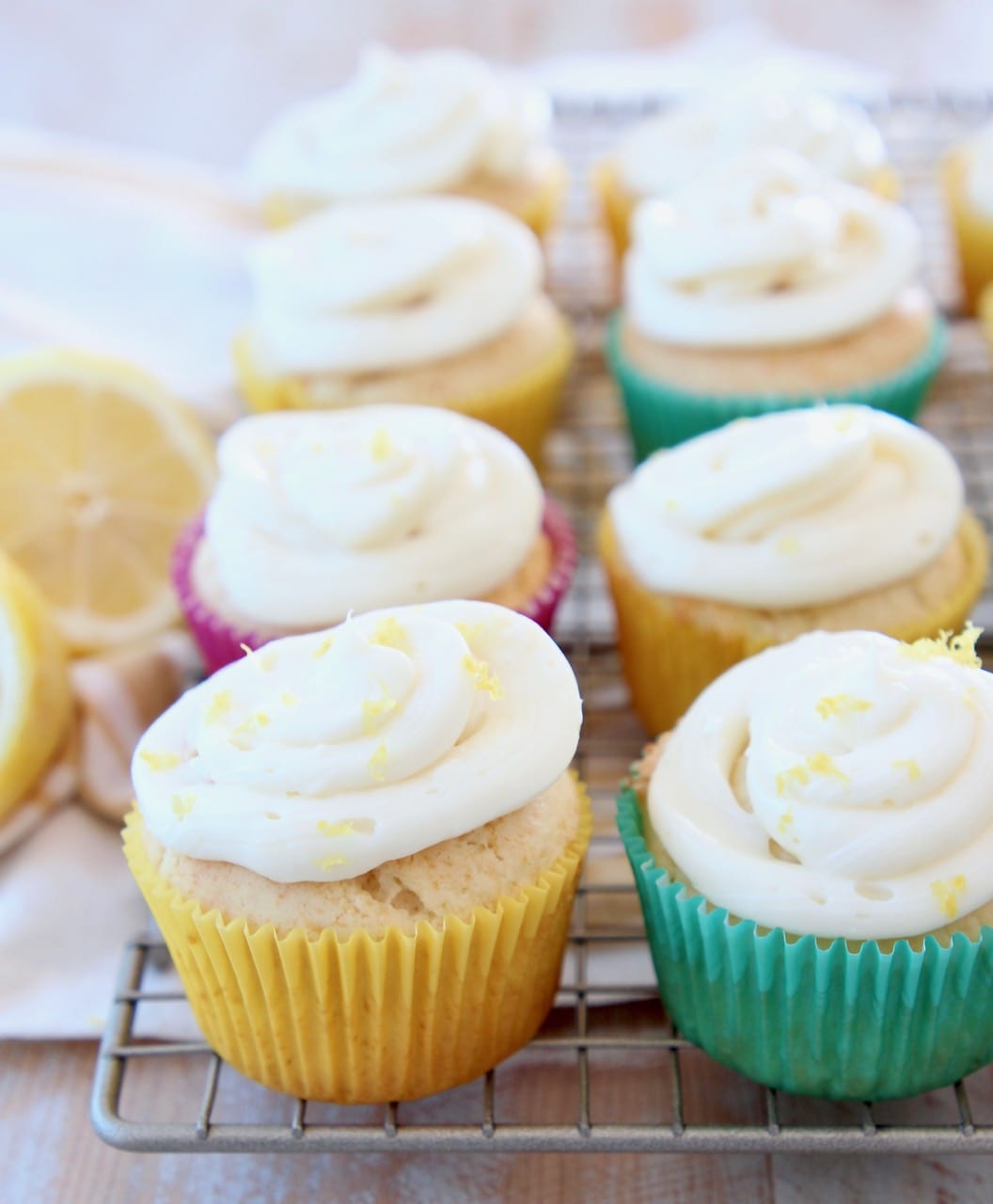 Lemon cupcakes with cream cheese frosting sitting on wire rack