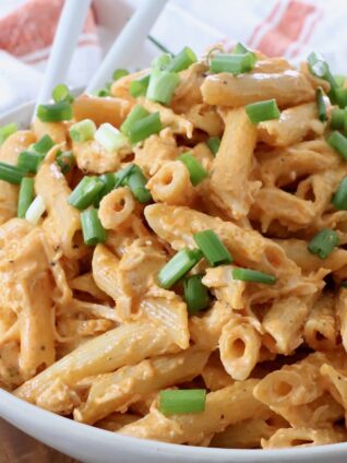 buffalo chicken pasta in bowl topped with diced green onions