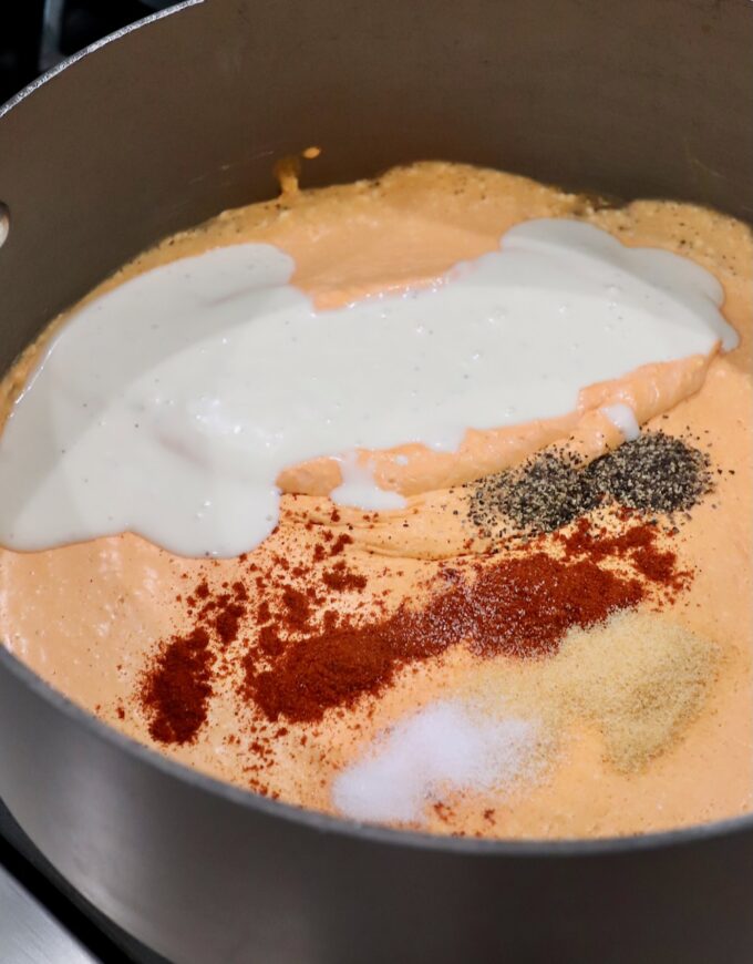 creamy buffalo sauce topped with spices and blue cheese dressing in large pot