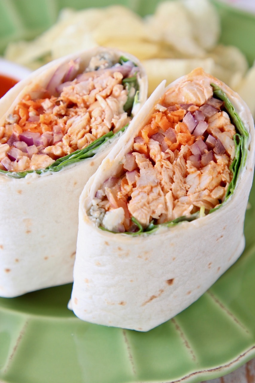 Buffalo chicken wrap sliced in half on green plate