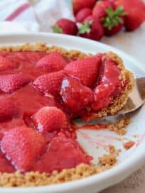 Slice of strawberry pie coming out of pie plate