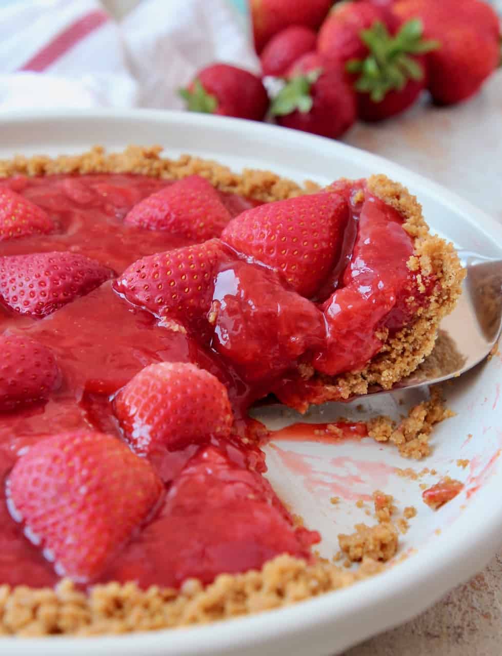 Slice of strawberry pie coming out of pie plate