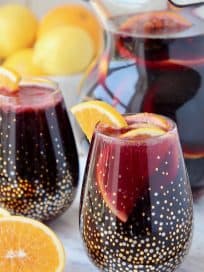 Red sangria in glasses and pitcher with oranges
