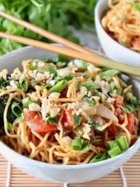 Thai peanut noodles in bowl with chopsticks on the side