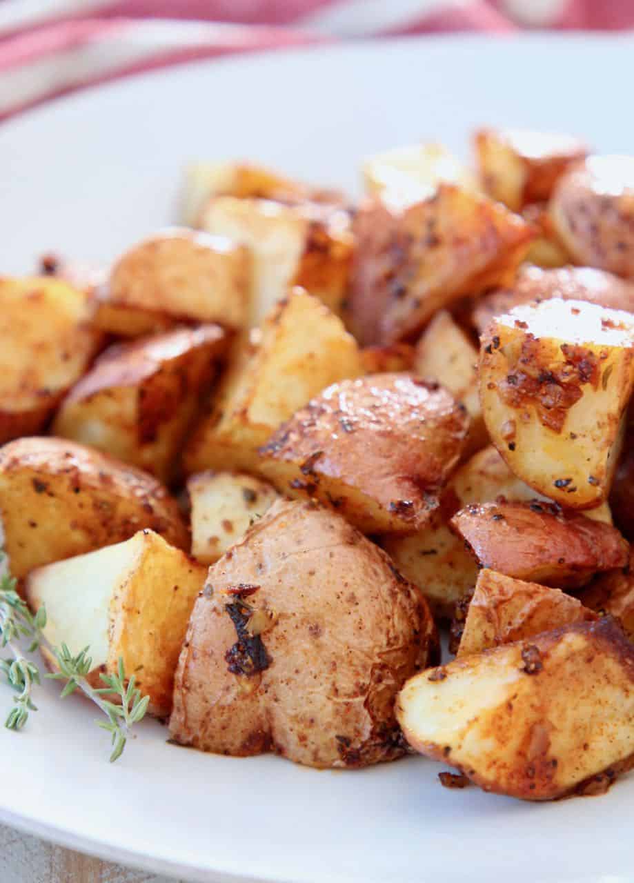 Oven roasted cubed Cajun potatoes on white plate