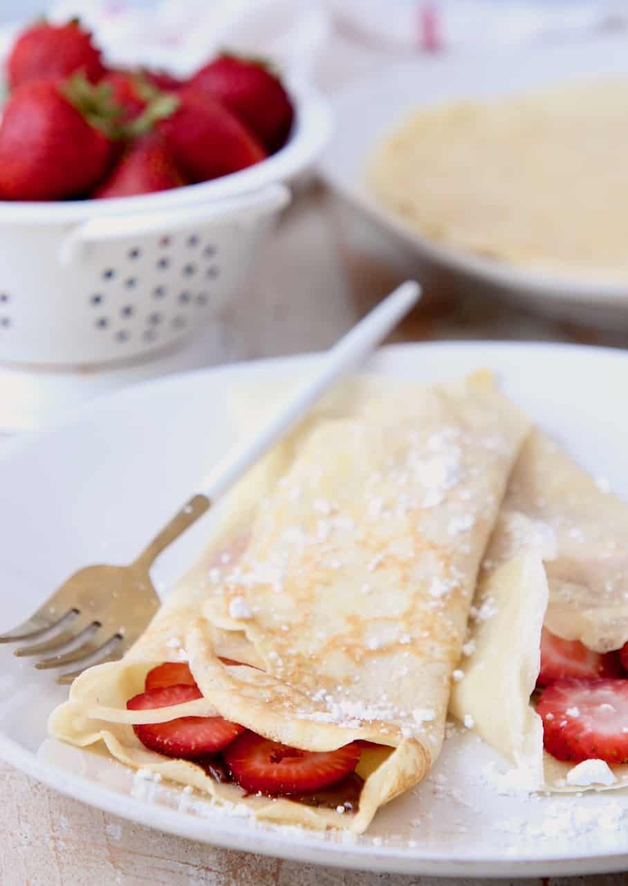 Nutella strawberry filled crepes on plate with fork