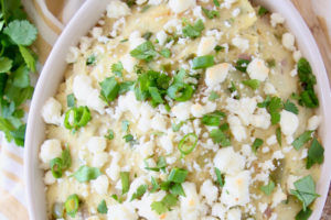 Overhead shot of Mexican mashed potatoes in an oval bowl topped with queso fresco and cilantro