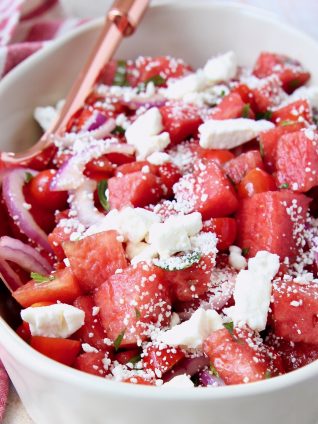 Diced watermelon and feta cheese crumbles in bowl with spoon