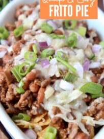 frito chili pie in white oval bowl topped with diced green onions