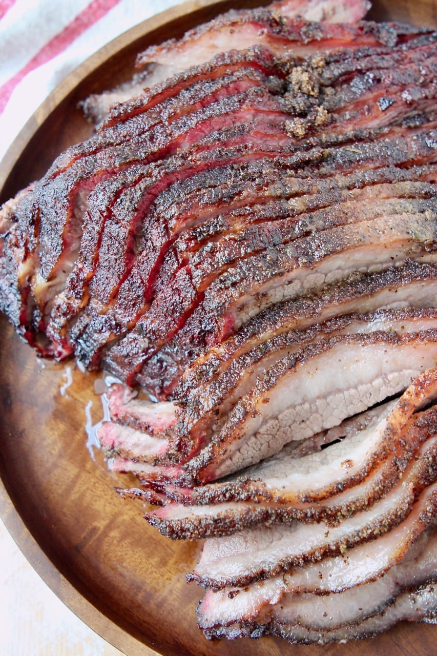 Sliced smoked brisket on wood serving platter