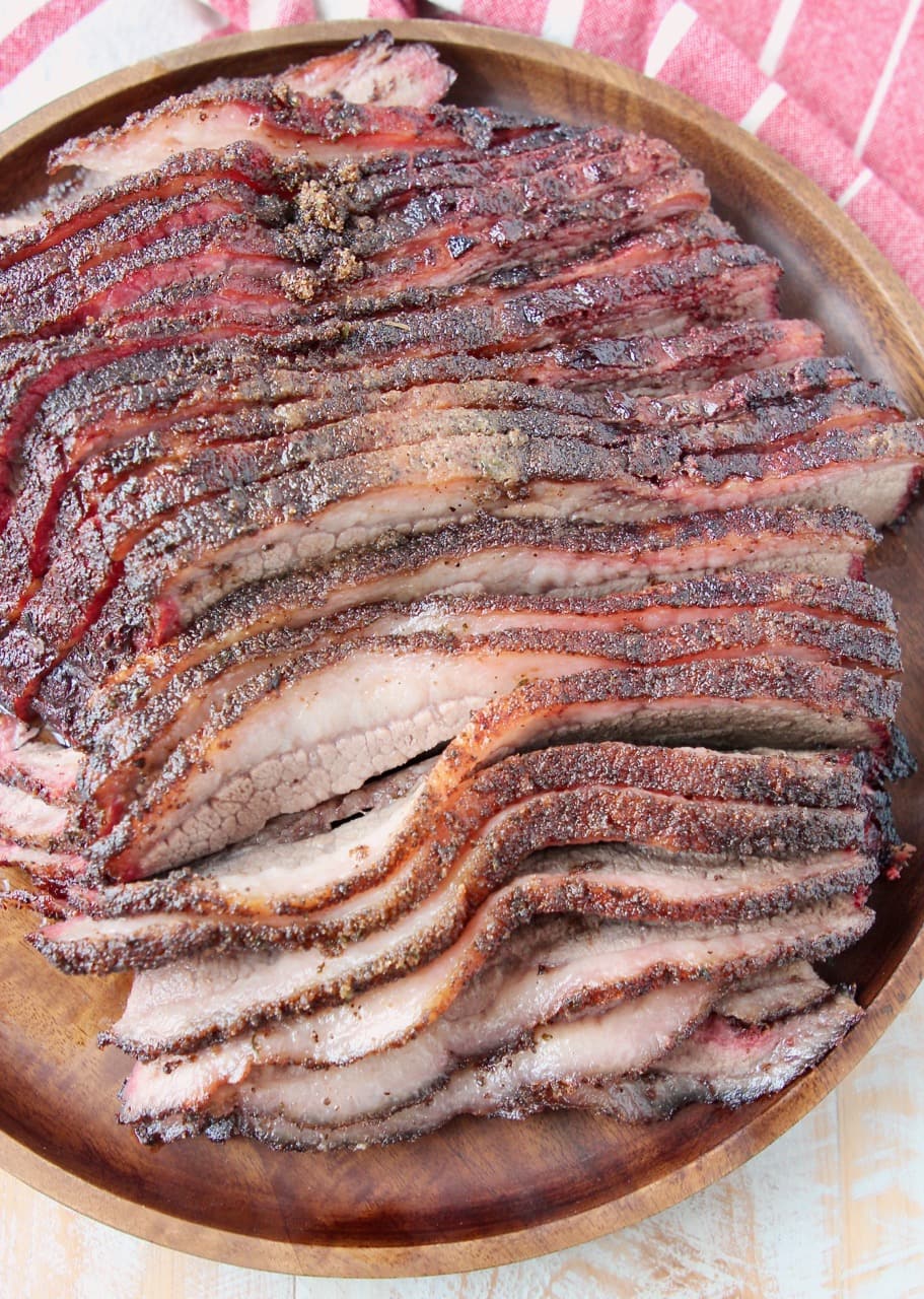 Overhead shot of sliced brisket on round wood serving tray