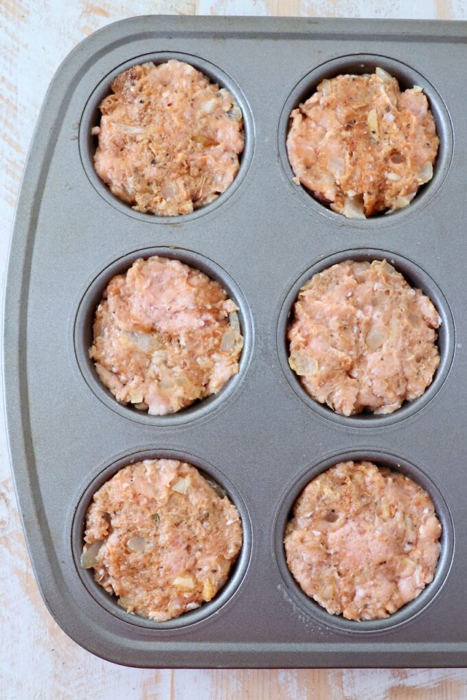 ground turkey meatloaf mixture pressed into a muffin tin