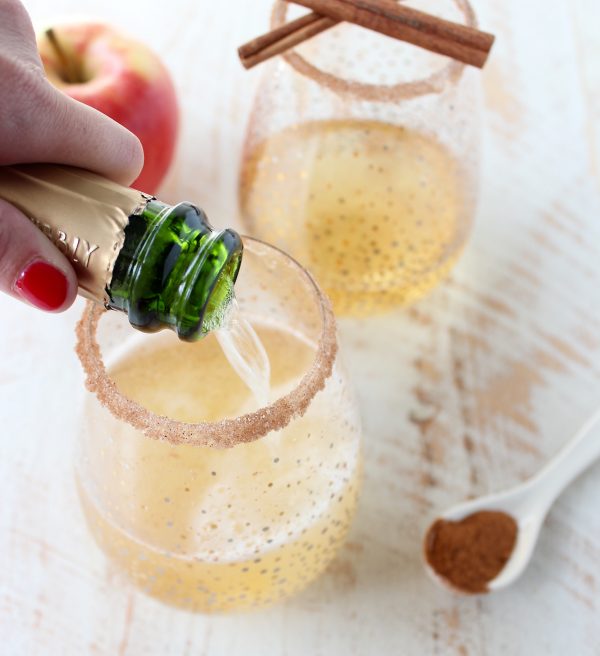 Rich apple cider is paired with sparkling champagne, vodka, maple syrup, cinnamon and nutmeg to make a festive fall apple cider champagne cocktail!