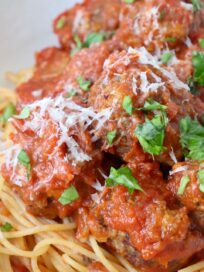 meatballs covered in tomato sauce in bowl with spaghetti