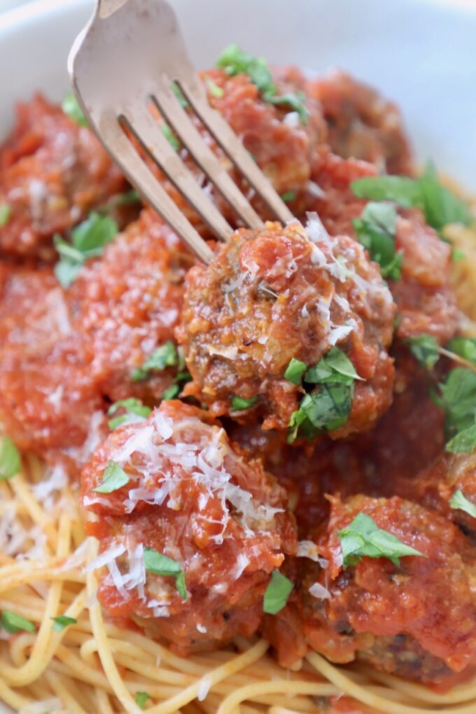 italian meatballs in bowl with spaghetti and fork