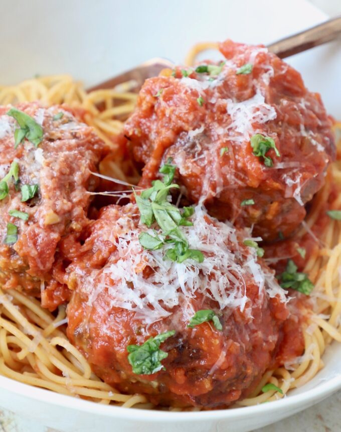 large Italian meatballs in bowl with spaghetti