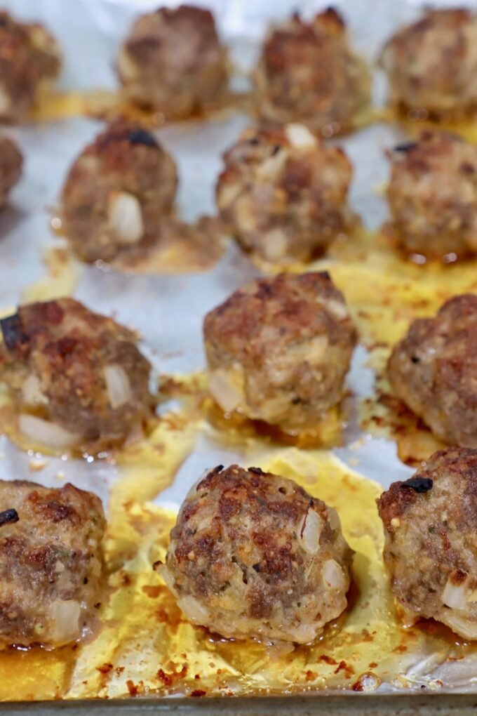 cooked meatballs on foil lined baking sheet