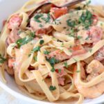 cajun shrimp and sausage pasta in bowl with fork