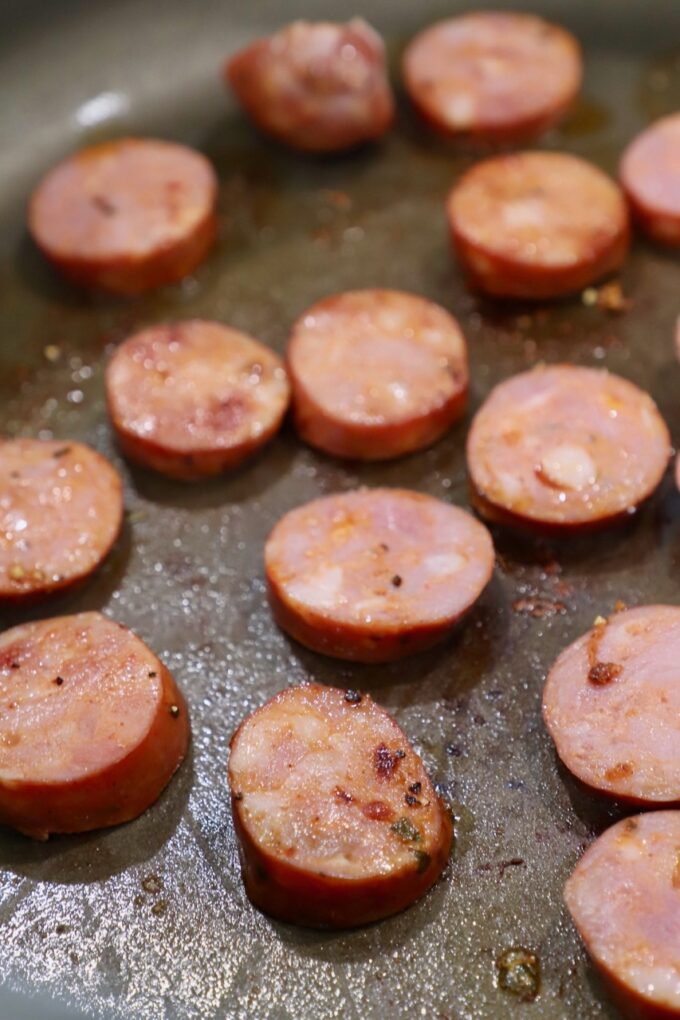 sliced sausage cooking in pan