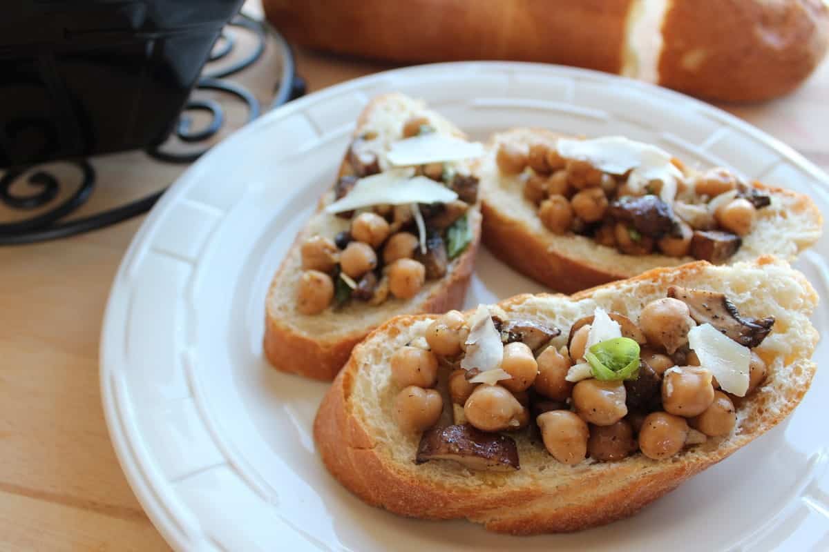 diced mushrooms and chickpeas on top of bread on a plate