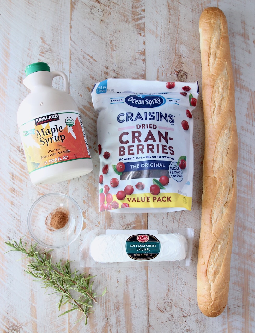 ingredients for cranberry goat cheese crostini on a white wood board