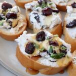 goat cheese and dried cranberry crostini on a plate