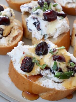 goat cheese and dried cranberry crostini on a plate