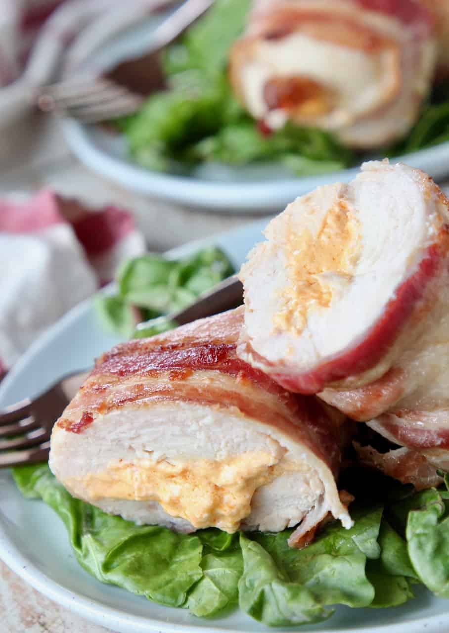 Sliced stuffed chicken breast on plate with salad