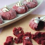 Red velvet cookie dough is rolled in powdered sugar to form a beautiful red and white crinkle cookie, topped with Hershey's hugs, these are the perfect Valentine's Day treat recipe.