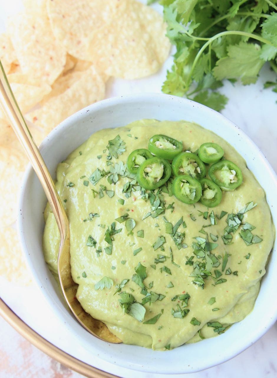 Avocado salsa in bowl, with tortilla chips on the side