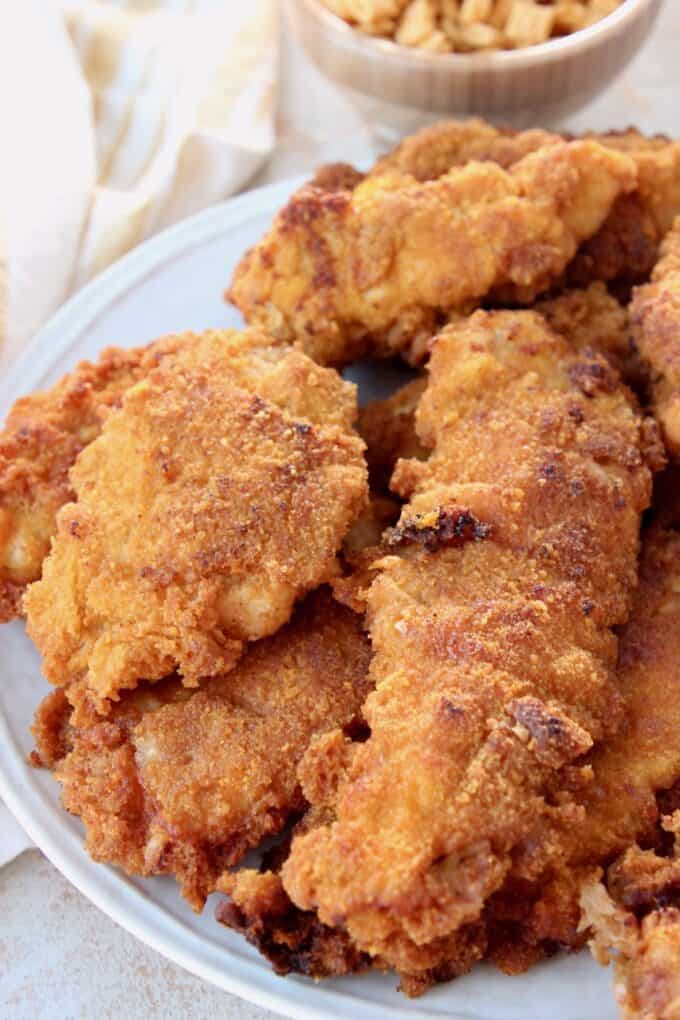 stacked up fried chicken strips on plate