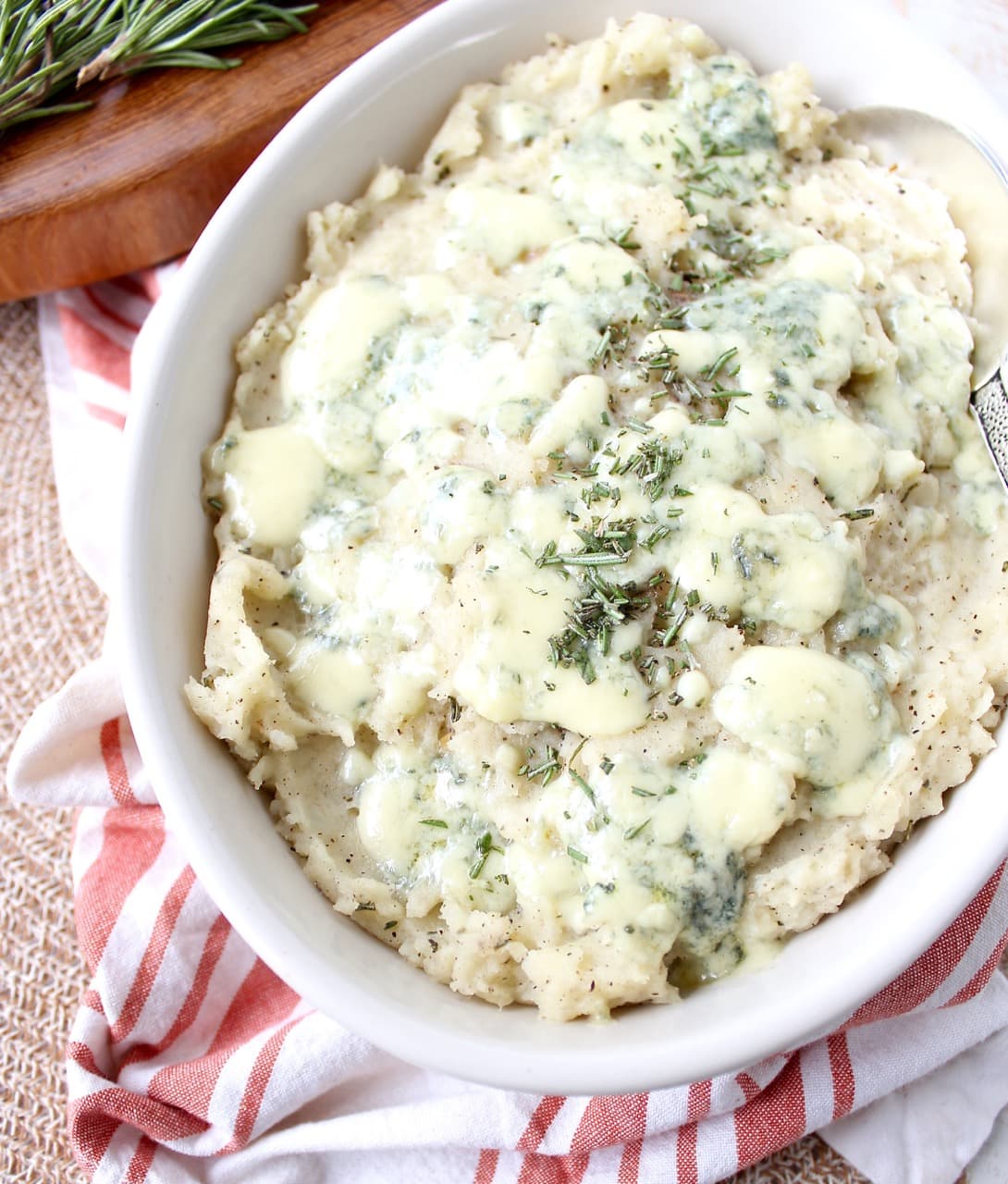 mashed potatoes in bowl topped with melted blue cheese crumbles