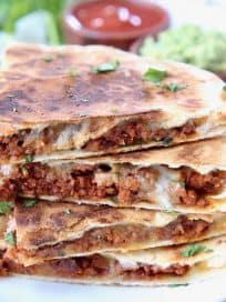 Stacked up slices of soy chorizo quesadilla on plate
