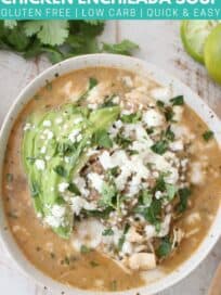 overhead image of chicken enchilada soup in bowl topped with sliced avocado