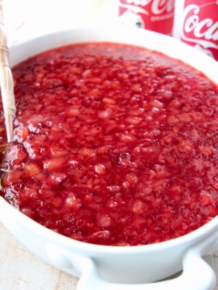 cherry jello salad in white serving bowl with spoon