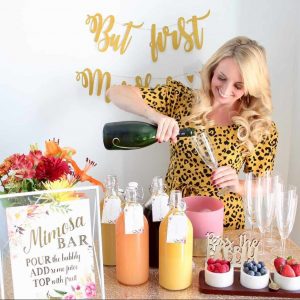 Woman pouring champagne into glass at a mimosa bar