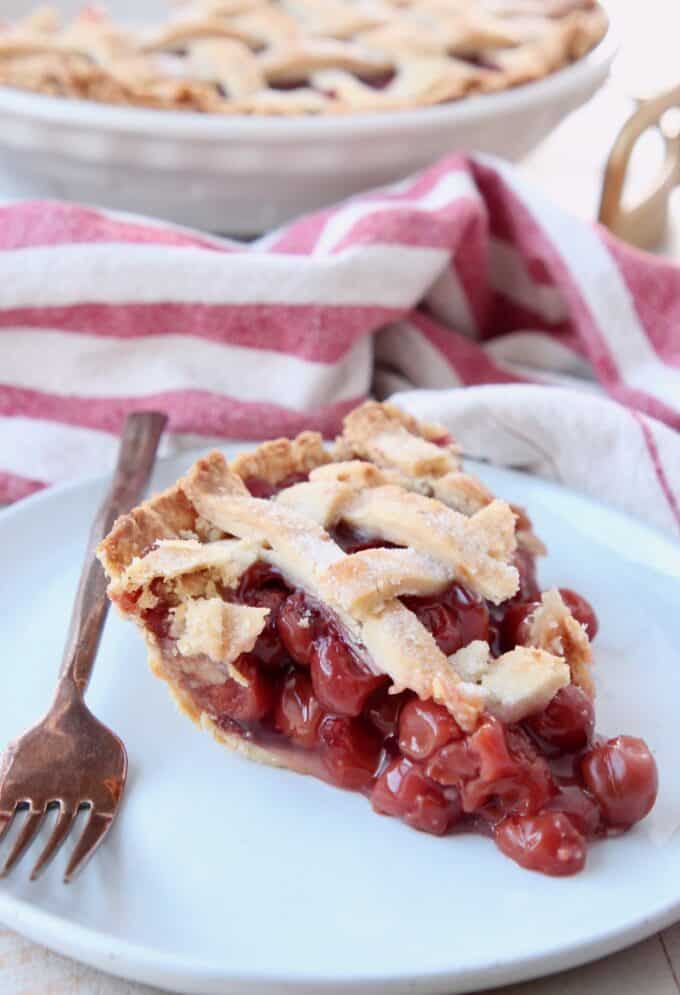 Slice of cherry pie on plate with fork
