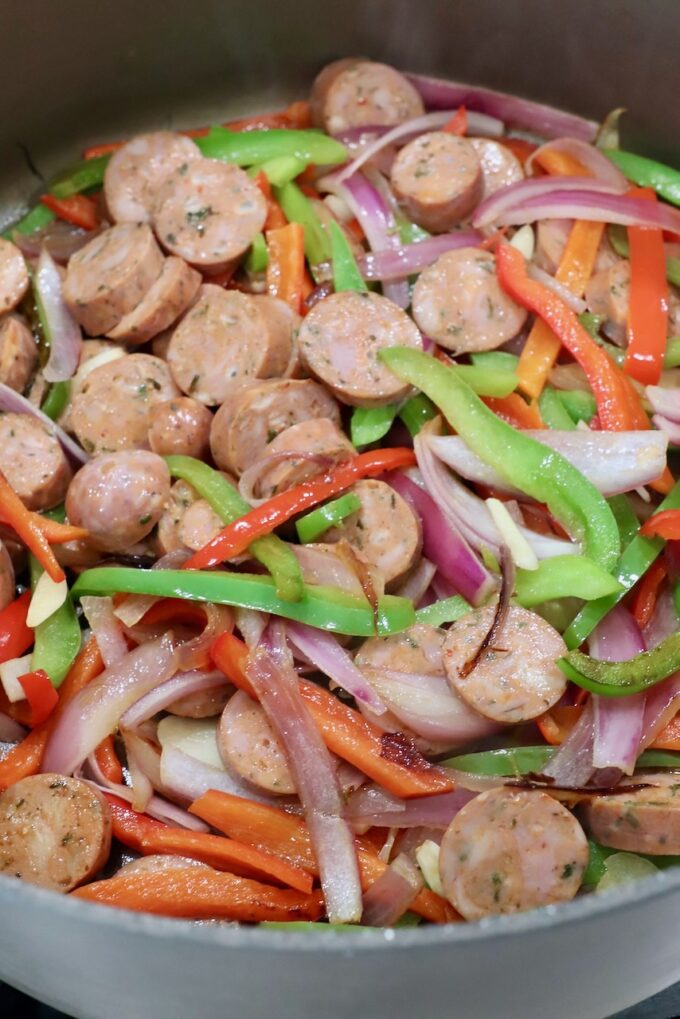 sliced Italian sausage and bell peppers in a large pan