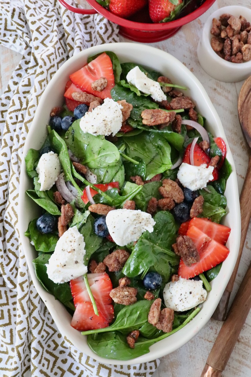 salad in large serving bowl topped with strawberries and ricotta cheese