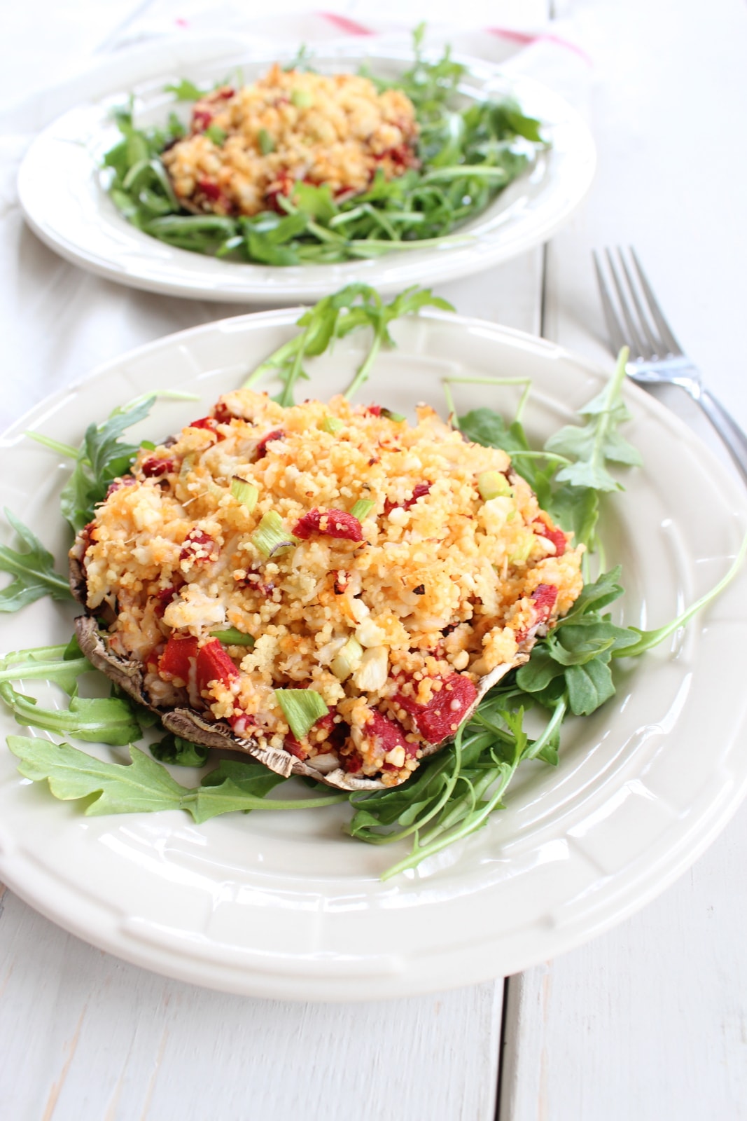 Couscous Stuffed Mushroom on a bed of arugula on a plate