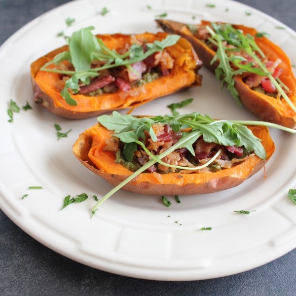 Vitamin packed sweet potatoes are filled with healthy, paleo, sage walnut pesto, crispy bacon and fresh arugula for delicious Paleo Sweet Potato Skins.