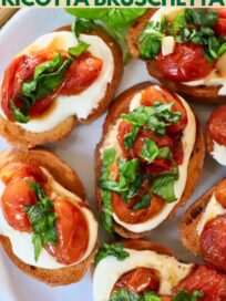 whipped ricotta and roasted tomato bruschetta on a plate with fresh basil leaves