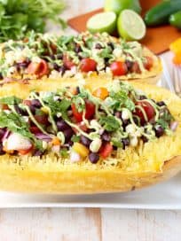 This Mexican Stuffed Squash recipe combines roasted spaghetti squash with black bean corn relish & avocado dressing for a simple vegan & gluten free meal!