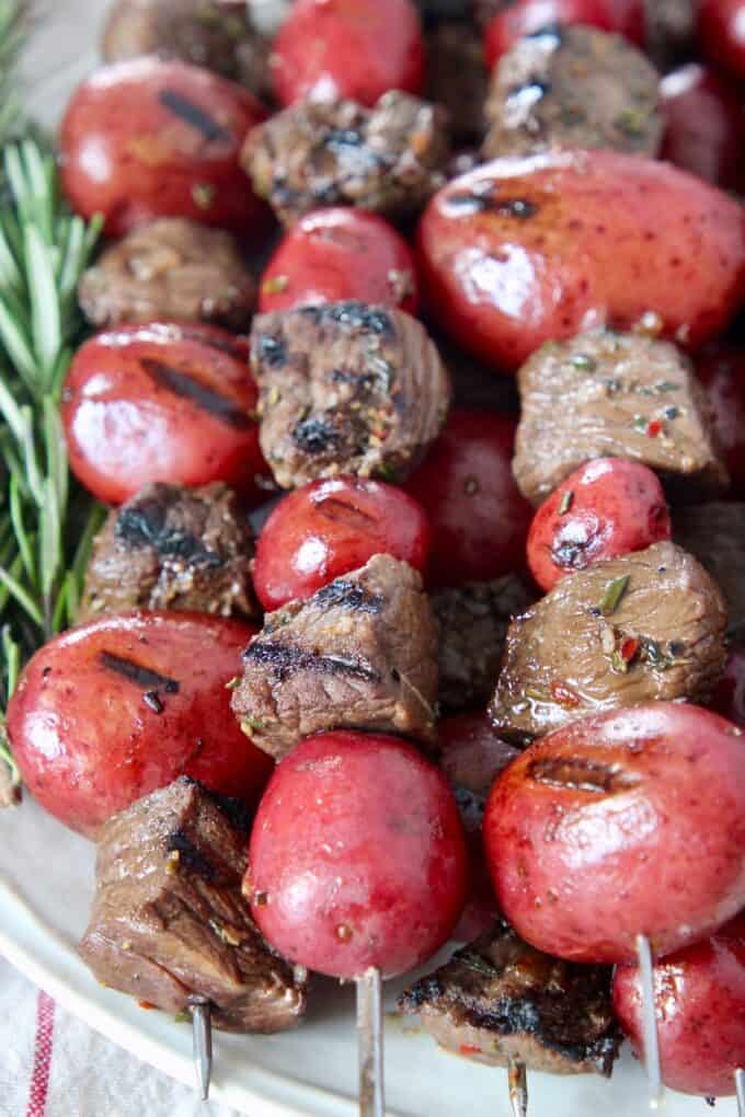 grilled pieces of steak and baby potatoes on skewers
