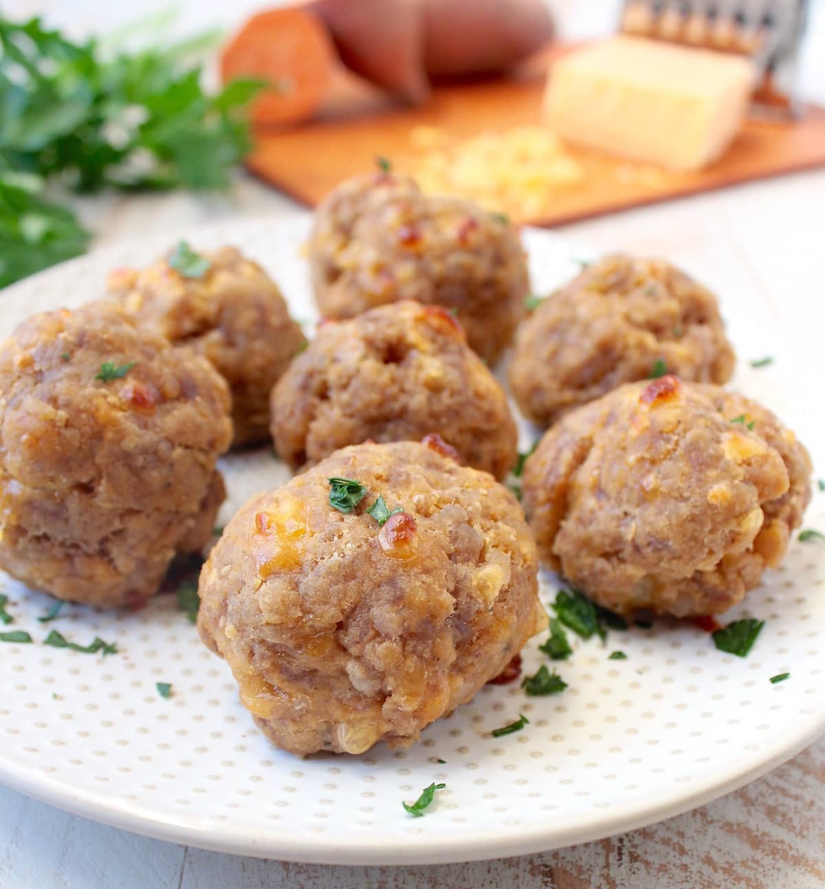 Sweet potato sausage balls on a white plate.